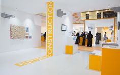 the interior of an art gallery with yellow and white accents