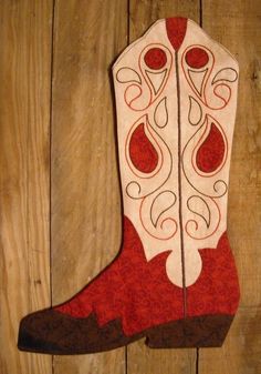 a red and white cowboy boot hanging on a wooden wall next to a wood floor