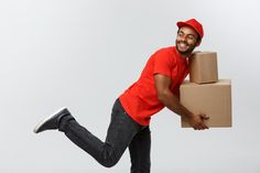 a man in red shirt and cap carrying boxes on his back with one foot up