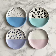 three plates with different designs on them sitting on a marble surface