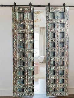 an ornate door is shown in front of a mirror with the reflection of a living room