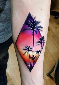 a person with a tattoo on their arm that has a sunset and two palm trees