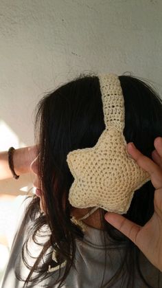 a woman wearing a crocheted headband with a star on it