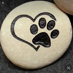 two rocks with designs on them and one has a dog's paw in the shape of a heart