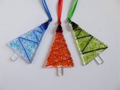 three different colored glass ornaments hanging from strings