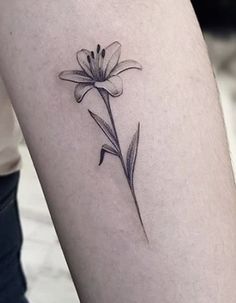 a single flower tattoo on the right thigh and lower leg, is shown in black ink