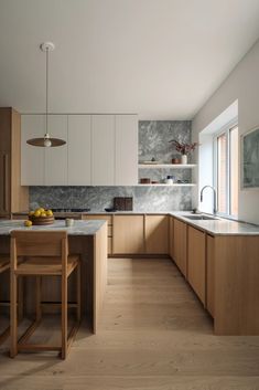 a kitchen with wooden cabinets and marble counter tops, along with an island in the middle