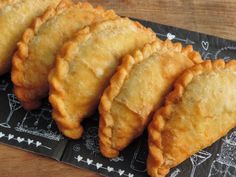 several pastries are lined up on a black plate