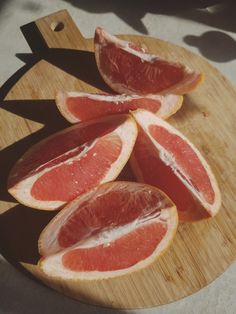 grapefruit sliced up on a wooden cutting board