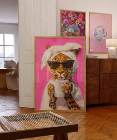 a leopard wearing sunglasses and holding a coffee cup in front of two paintings on the wall