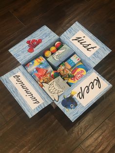 an open box filled with candy on top of a wooden floor