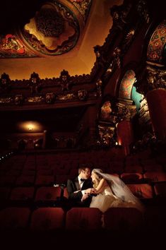 a bride and groom sitting in an auditorium