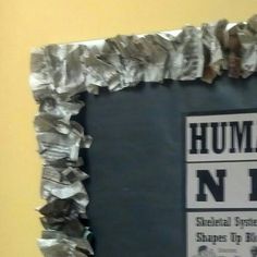 a bulletin board with newspaper paper on it and a sign that reads human rights now