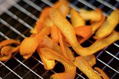 some orange peels are on a metal grill grate and they are not ripe enough to eat