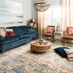 a living room filled with furniture and a chandelier hanging over the top of it