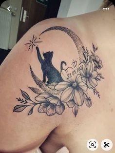 the back of a woman's shoulder with flowers and a cat on it