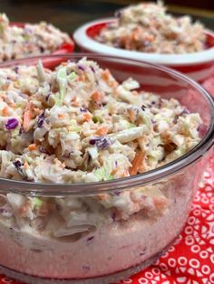 a bowl filled with salad sitting on top of a red and white tablecloth covered table