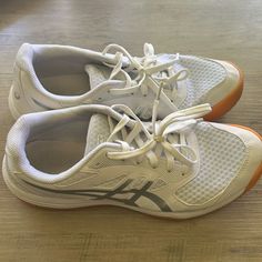 a pair of white and orange running shoes