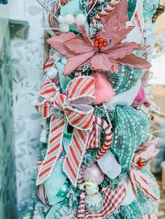 a christmas tree decorated with red, white and green ribbons