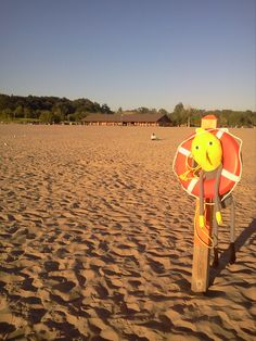 a life preserver on the beach with trees in the background