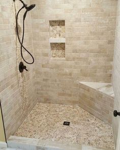 a walk in shower sitting next to a tiled wall