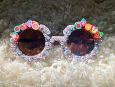 Fruity Sunglasses handmade for your fabulous & fun toddler/child!    * for kids ages 1 to over 5  * (check the size below before ordering if you are unsure.)   * Sunglasses bag provided for protection.  Perfect for outdoor activities, photoshoots, birthday parties, party favors, classroom gifts, beach, traveling, etc.!  If you have any other custom ideas, or clarifications, feel free to message me directly! I am open to custom designs.  *Please note that if you request a different customization, I am likely able to do it, but it may take longer if I do not have the supplies available at the time of request. I will guarantee that I will do my best to oblige to custom orders within reasonable requests. *  No refunds or returns.  If there is an issue upon arrival of product - please contact m Fun Multicolor Sunglasses For Festivals, Fun Multicolor Festival Sunglasses, Multicolor Plastic Sunglasses For Birthday, Fun Handmade Pink Sunglasses, Handmade Fun Pink Sunglasses, Fun Pink Handmade Sunglasses, Playful Tinted Lens Sunglasses For Festival, Playful Multicolor Glass Sunglasses, Fun Handmade Sunglasses As A Gift