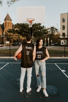 two people standing in front of a basketball hoop