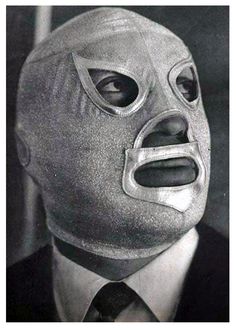 a man in a suit and tie wearing a mask