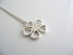 Overview:Offered for sale is a gorgeous Tiffany & Co Sterling Silver Nature Open Flower necklace. The necklace is a wonderful piece that is simple, elegant, and classic all rolled into one. It works perfectly with pretty much any attire your put on, AND adds a nice feminine touch to it. It is a wonderful necklace that fits a lifestyle on the go -- the necklace can be worn to pretty much any occasion! Imagine the piece with your professional office attire ... Now imagine it with jeans or week Open Flower, Nature Necklace, Matching Rings, Charm Gift, Flower Necklace, Tiffany & Co., Solid 925 Sterling Silver, Silver Necklace, 925 Sterling Silver