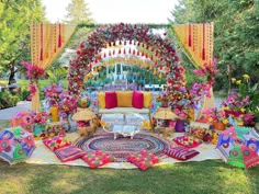 an outdoor ceremony with colorful decorations and flowers on the altar, surrounded by lush greenery