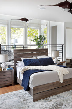 a bedroom with a bed, dressers and ceiling fan in the middle of it