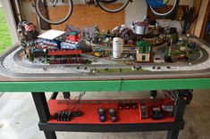 a toy train set sitting on top of a table next to a pair of bikes