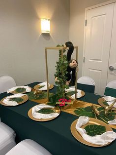 the table is set with plates, napkins and monkey figurines on them