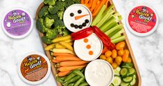 an assortment of vegetables and dips are arranged in the shape of a snowman