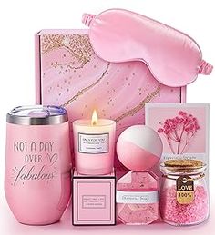 a pink gift set with an eye mask, candle and other items