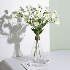 a vase filled with white flowers sitting on top of a table