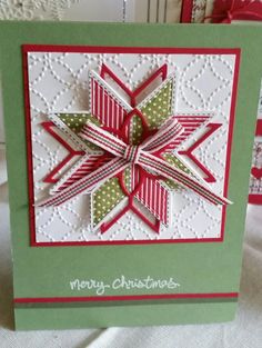 a christmas card with a paper snowflake on the front and green envelopes in the back