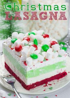 a christmas cake with marshmallows and candy on top sits on a plate