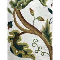 a close up view of a tree with leaves and vines on white fabric, as well as green foliage