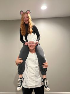 a man is holding a woman on his shoulders