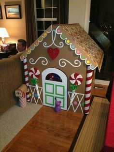 a gingerbread house made out of cardboard and decorated with candy canes