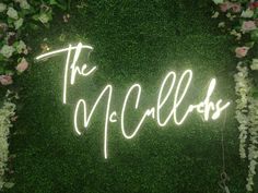 a neon sign that says the mcclliss in white writing on a green wall