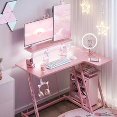 a pink desk with two computer monitors and a keyboard on it in a child's room