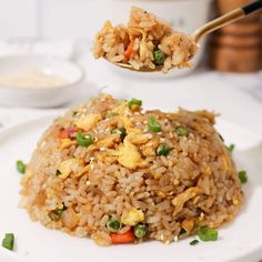 a white plate topped with fried rice and vegetables