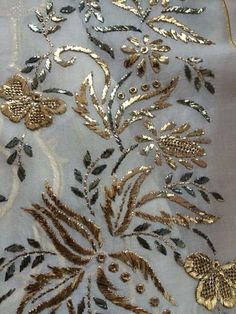 an embroidered fabric with gold flowers and leaves