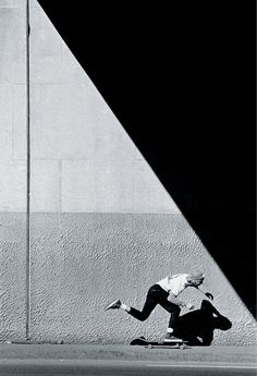 a man riding a skateboard next to a tall building