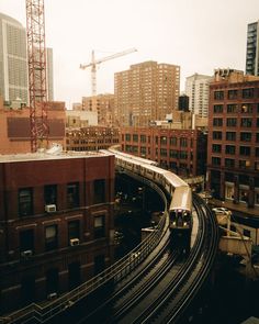 a train traveling through a city next to tall buildings