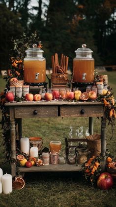 an old wooden table topped with jars filled with liquid and apples on top of it