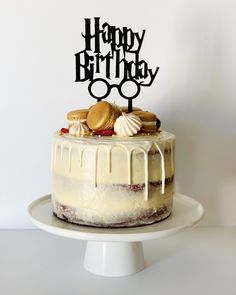 a happy birthday cake with glasses and cookies on top