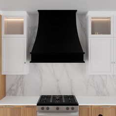 a stove top oven sitting inside of a kitchen next to white cabinets and cupboards